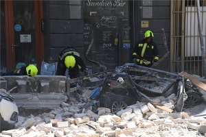 Homlokzati fal dőlt az utcára és parkoló autókra Budapest belvárosában